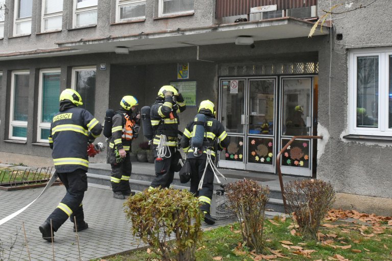 Hasiči se chystají na vstup do hořící budovy